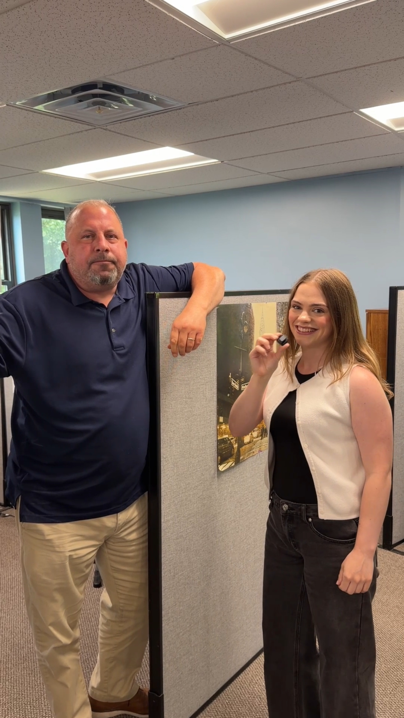 Teagan smiling with a coworker while filming a team video