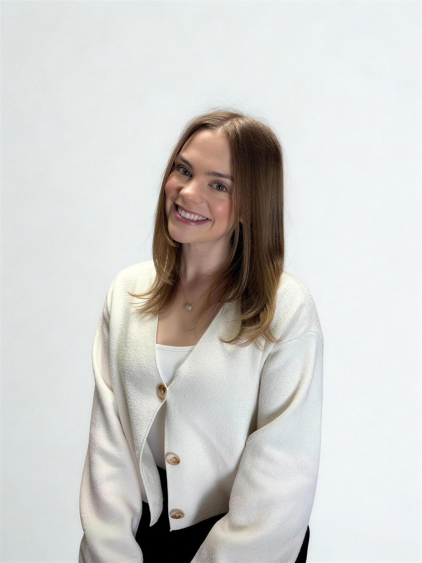 Portrait of Teagan McGinn smiling, in a cream cardigan